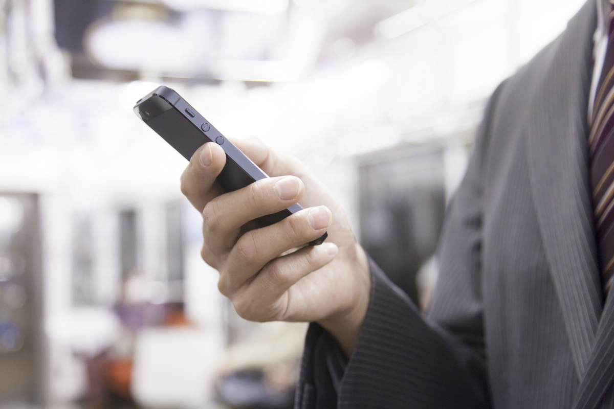 Ondernemer bekijkt voordelen van zakelijk mobiel abonnement op smartphone