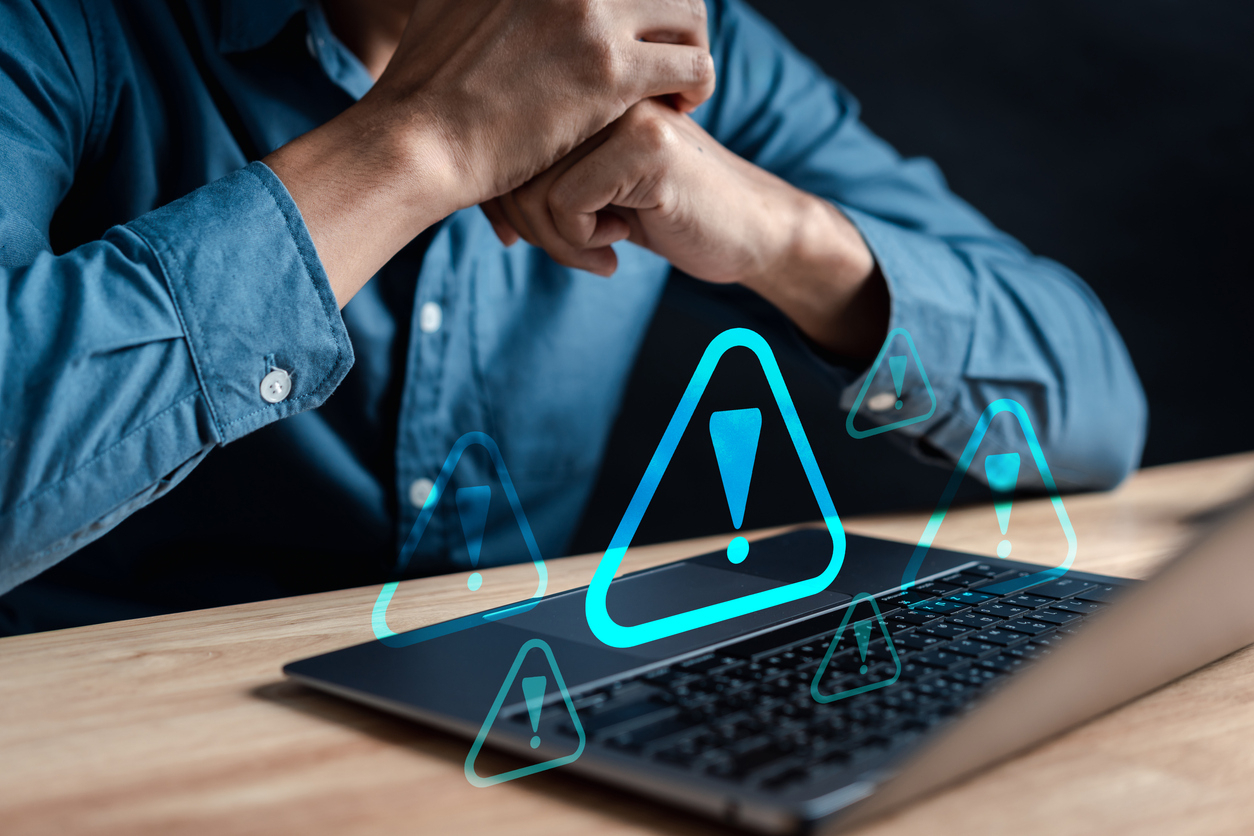 Man achter laptop met digitale waarschuwingsdriehoeken voor phishing voorkomen