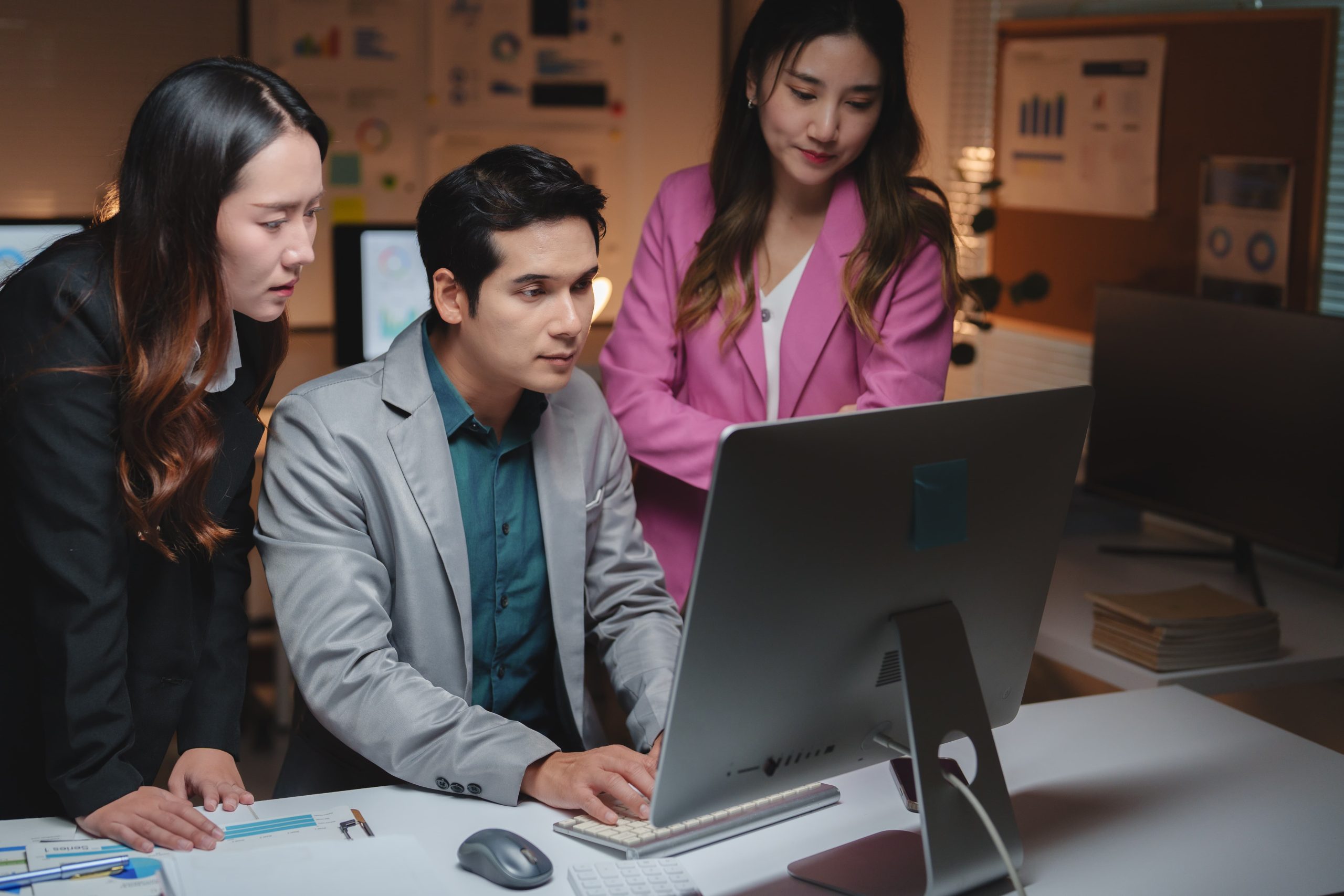 Team van professionals werkt samen aan een computer met Microsoft 365 Backup software in een moderne kantooromgeving